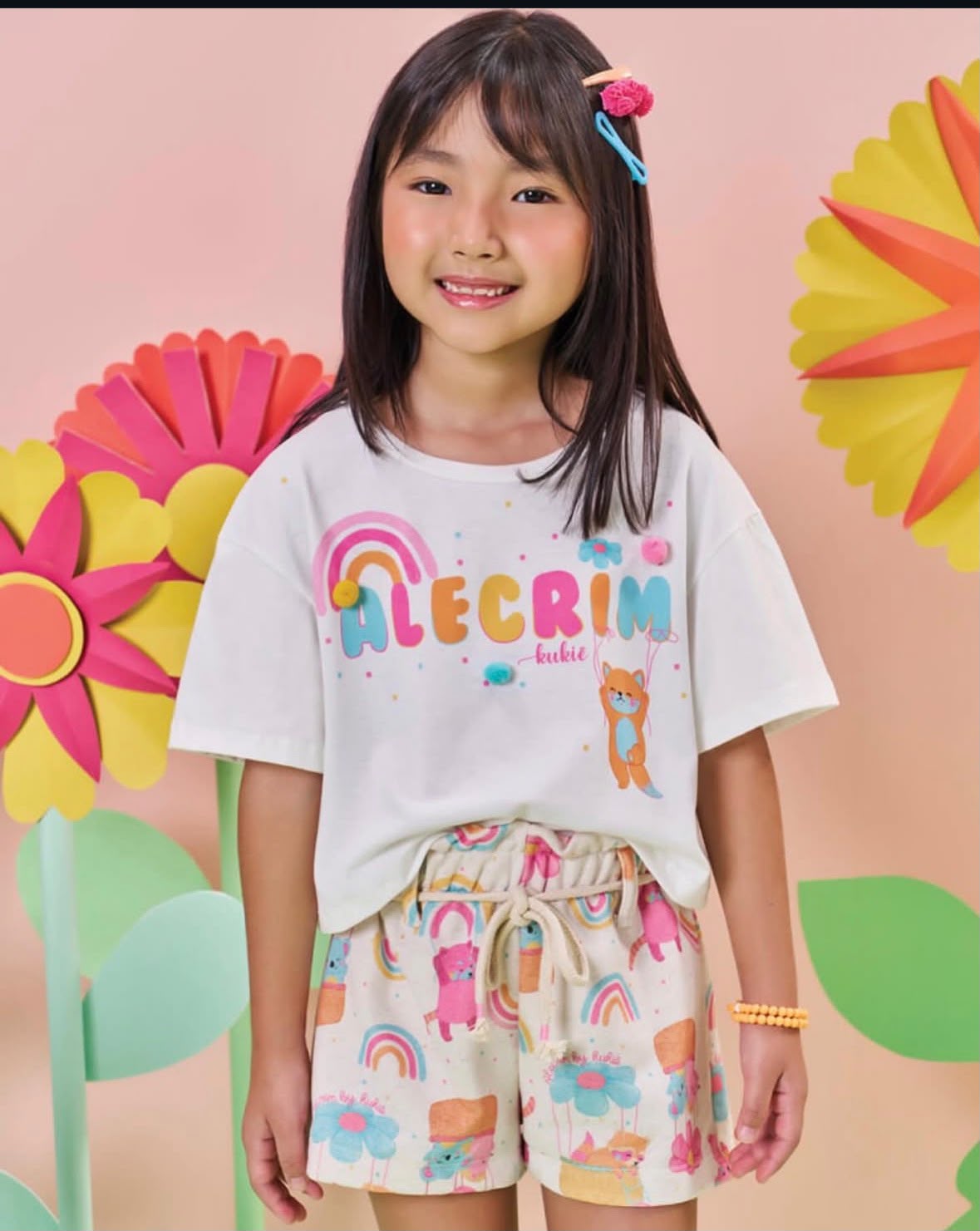 Menina vestindo conjunto colorido de camiseta e shorts da Doce Kids