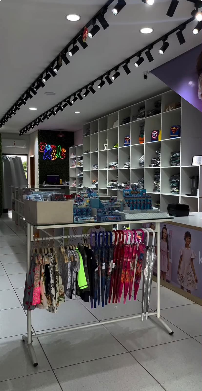 Interior da loja Doce Kids em Jundiaí, com araras de roupas infantis e o letreiro neon da marca