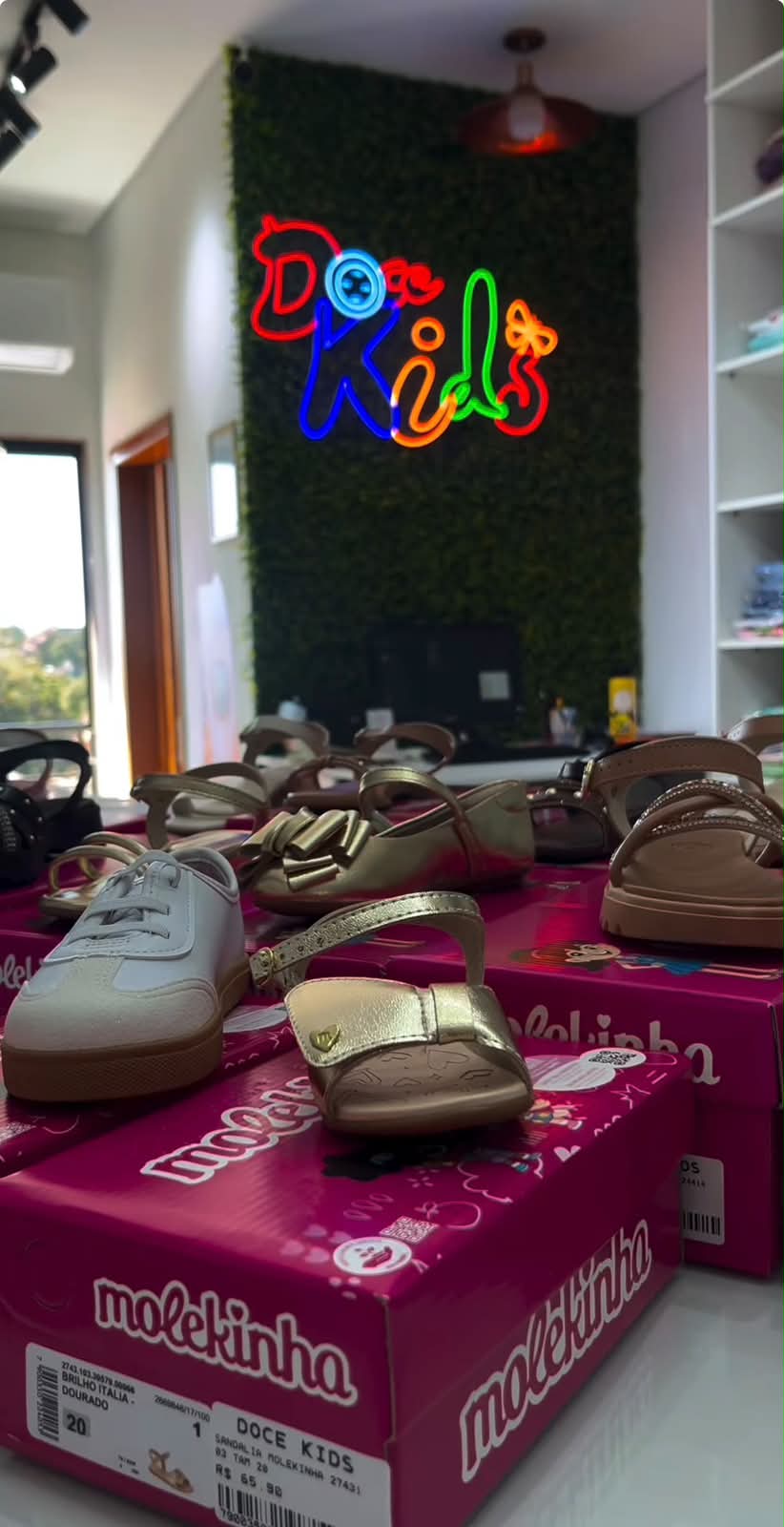 Calçados infantis expostos em caixas rosa dentro da loja Doce Kids