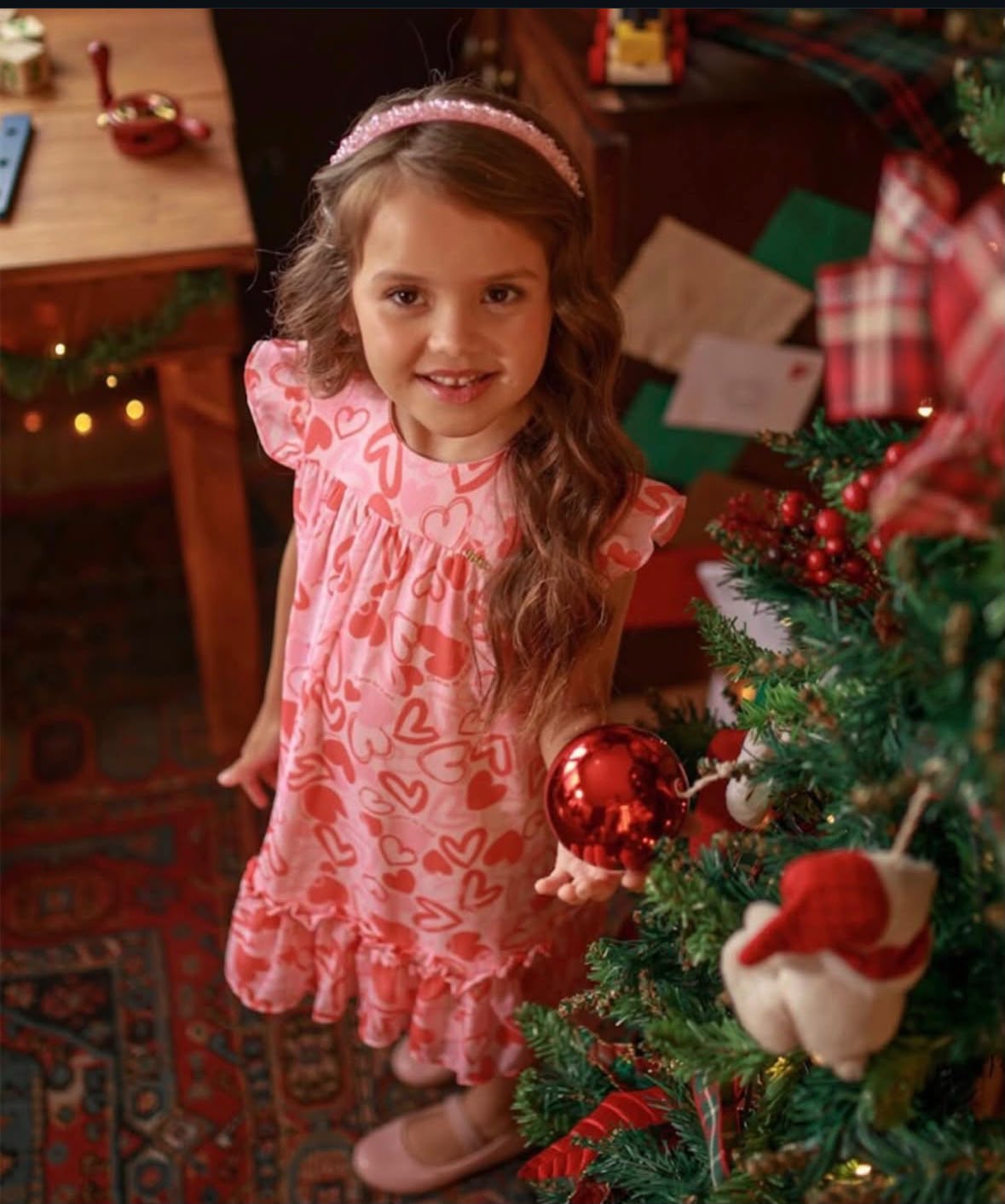 Menina vestindo vestido rosa de corações, look infantil da Doce Kids