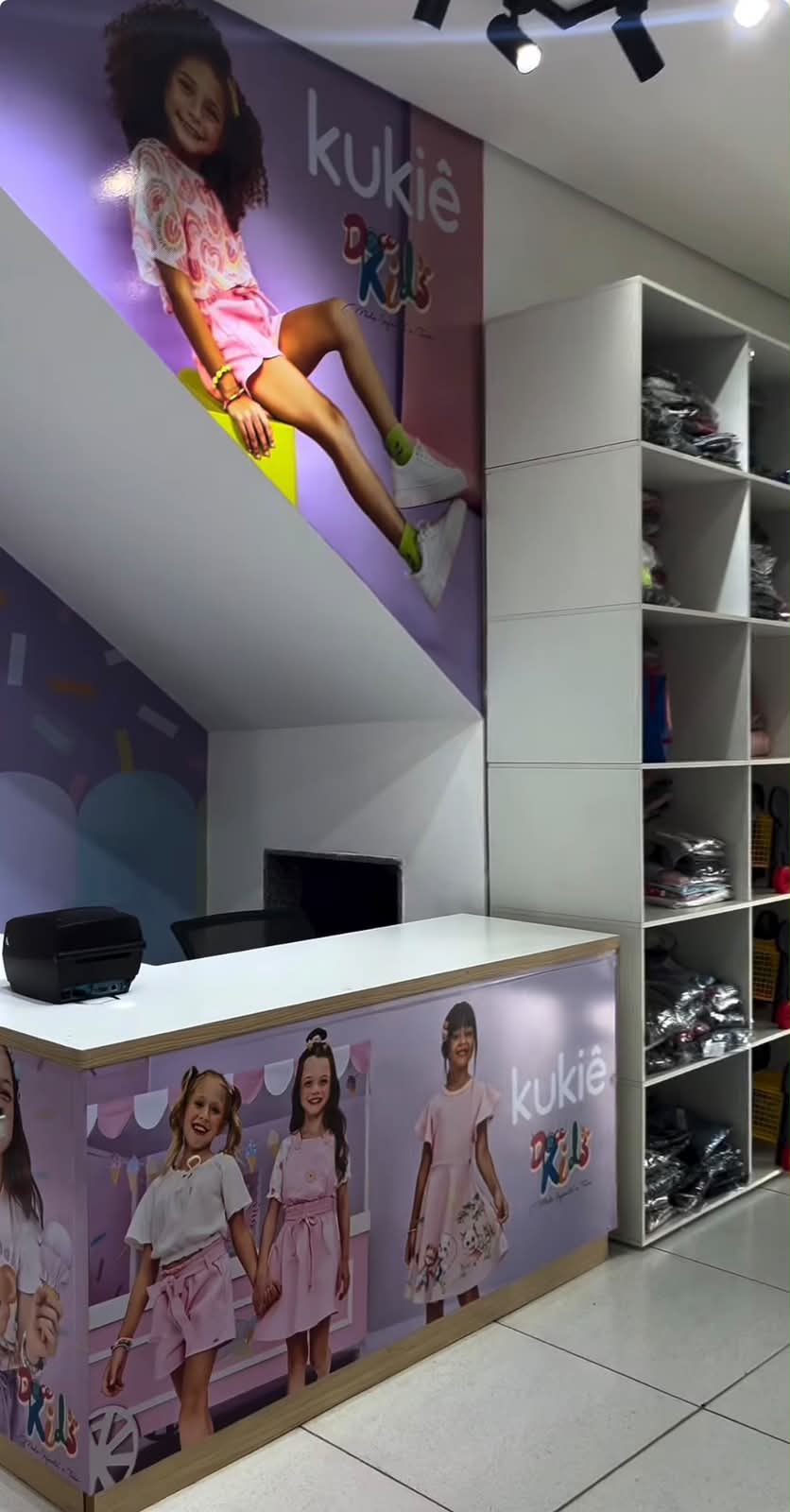 Balcão de atendimento da Doce Kids com painel da marca Kukie